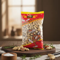 KSB roasted peanuts in shell packaging on a wooden board with peanuts scattered around.