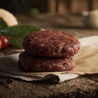 Two raw wild boar and chorizo burger patties on parchment with smoky paprika tones – The Black Farmer