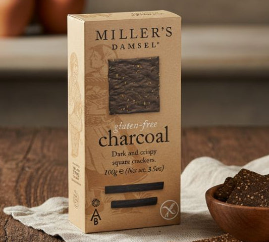 Box of Miller's Damsel charcoal crackers on a wooden table with crackers around
