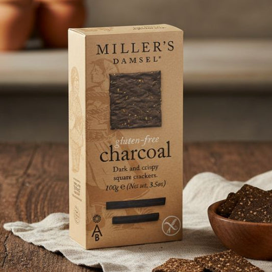 Box of Miller's Damsel charcoal crackers on a wooden table with crackers around