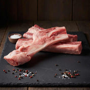 Raw beef bones on slate board with seasoning