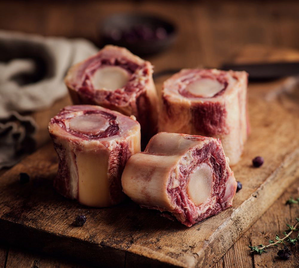Raw beef bones on a wooden cutting board with a rustic background