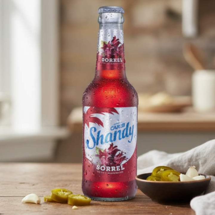 Bottle of Carib Shandy Sorrel on a wooden table with a blurred kitchen background