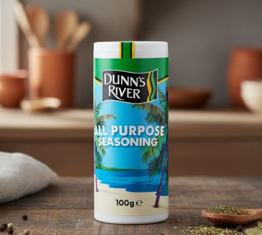 Dunn's River all-purpose seasoning canister on a wooden surface with kitchen items in the background