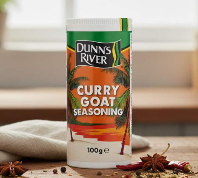 Dunn's River Curry Goat Seasoning container on a wooden surface with spices.