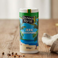Dunn's River jerk seasoning container on a wooden table with spices around