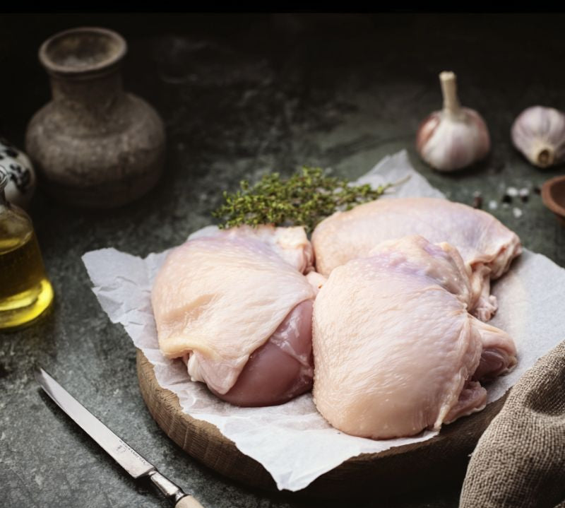 Free range British chicken thighs, bone-in and skin-on, on rustic wooden board — The Black Farmer