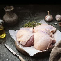 Free range British chicken thighs, bone-in and skin-on, on rustic wooden board — The Black Farmer