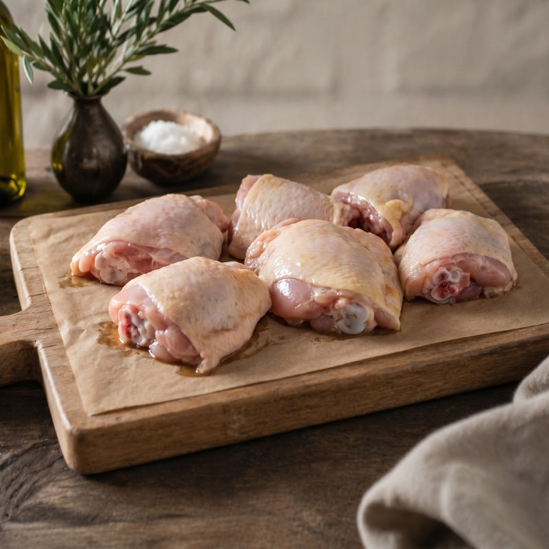 Free range British chicken thighs, bone-in and skin-on, on rustic wooden board — The Black Farmer