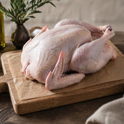 Free range whole British turkey on rustic table, premium white turkey ready for roasting.