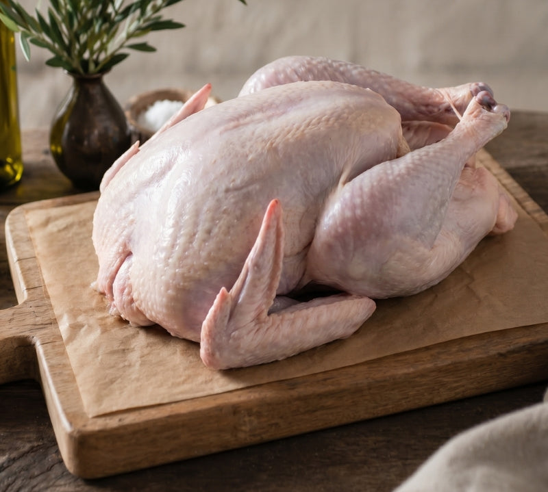 Free range whole British turkey on rustic table, premium white turkey ready for roasting.