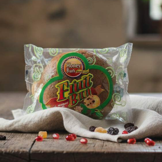 Packaged fruit bun on a wooden table with a blurred background