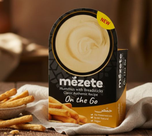 Mézete hummus packaging on a wooden table with fries and a blurred background