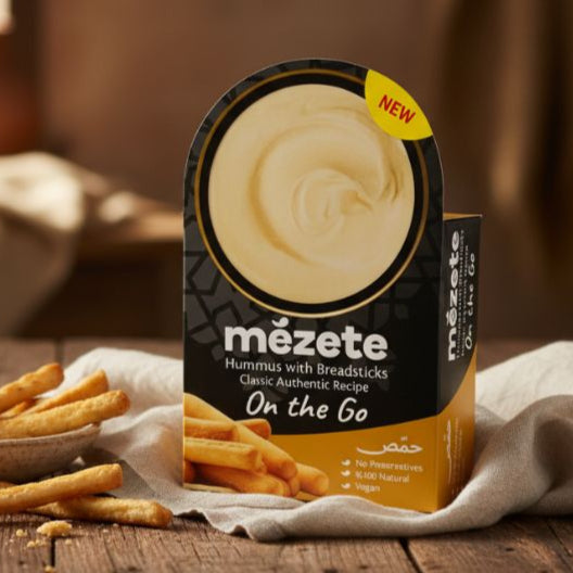 Mézete hummus packaging on a wooden table with fries and a blurred background