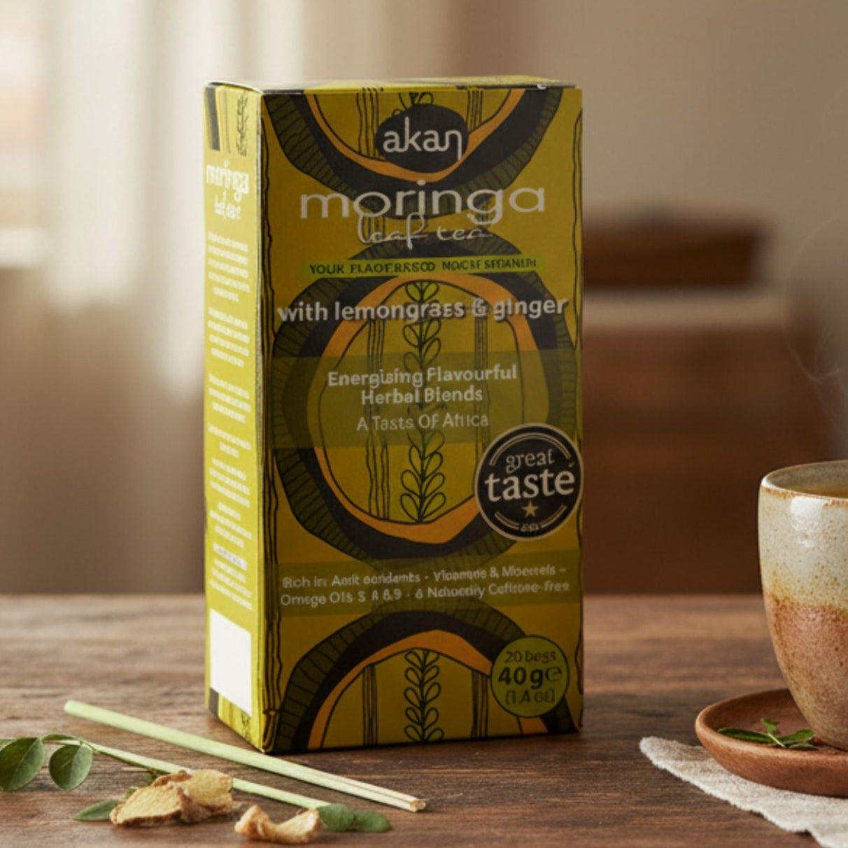 Acan Moringa tea box with a steaming cup of tea on a wooden table.