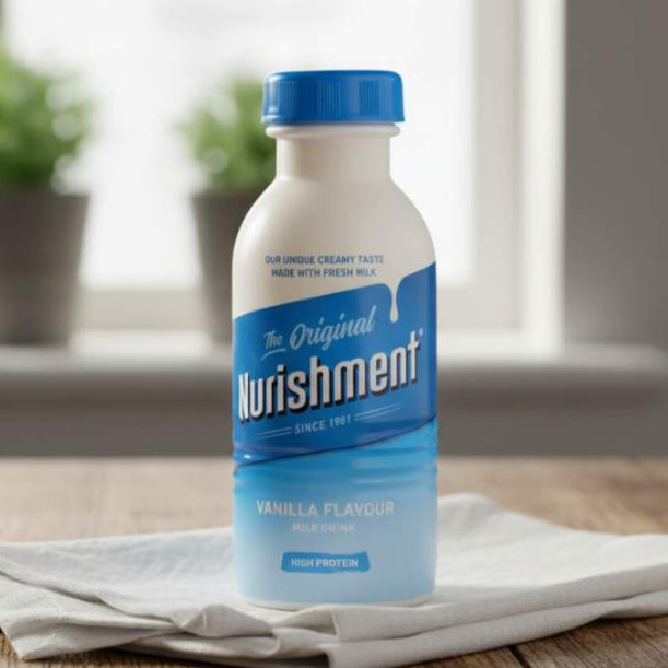 Bottle of Nutrishment Vanilla Flavour on a wooden surface with a blurred indoor background