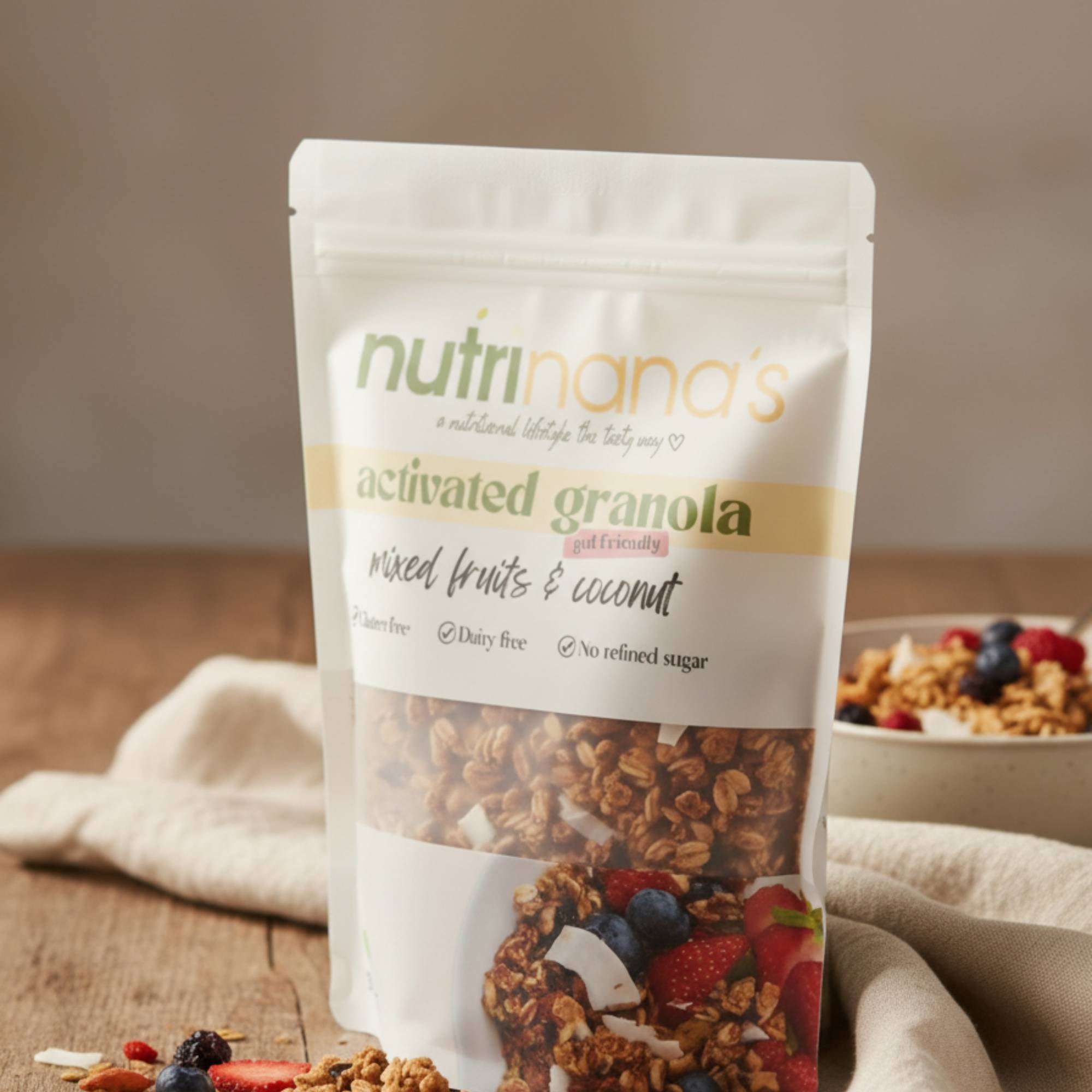 Package of Nutrinana's activated granola with a bowl of granola and fruits in the background.