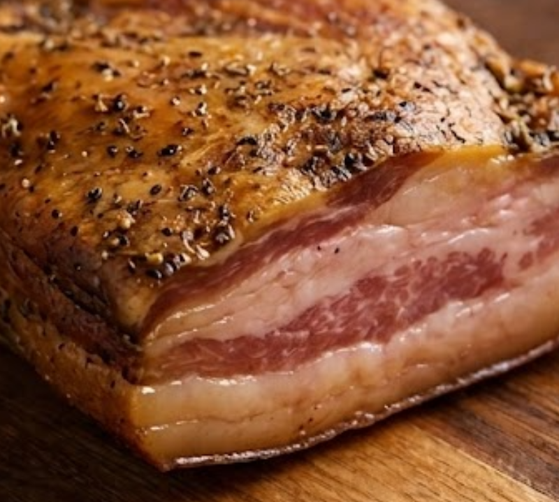 Smoked meat with a crispy exterior on a wooden surface