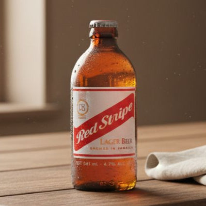 Red Stripe beer bottle on a wooden surface with a window in the background