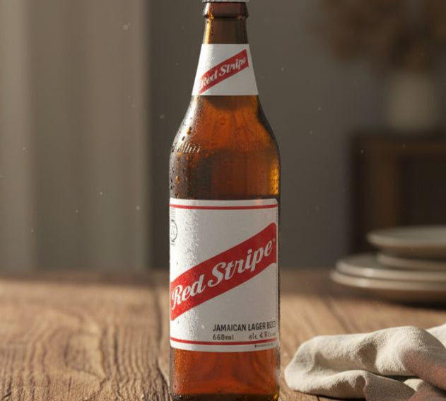 Red Stripe beer bottle on a wooden table with a blurred background