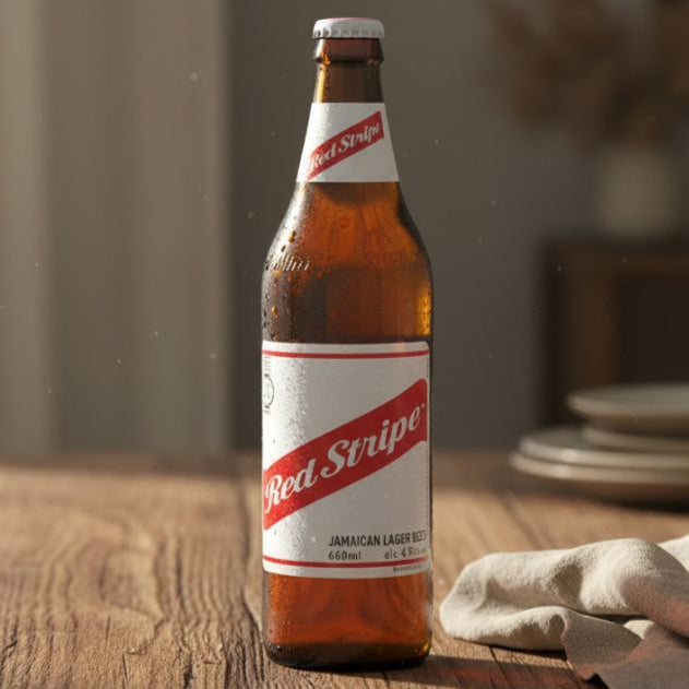 Red Stripe beer bottle on a wooden table with a blurred background