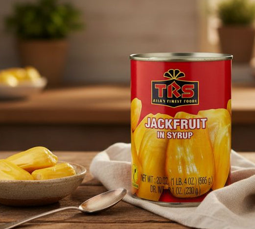 Tin of TRS Jackfruit in Syrup next to a bowl of yellow jackfruit chunks on a wooden table