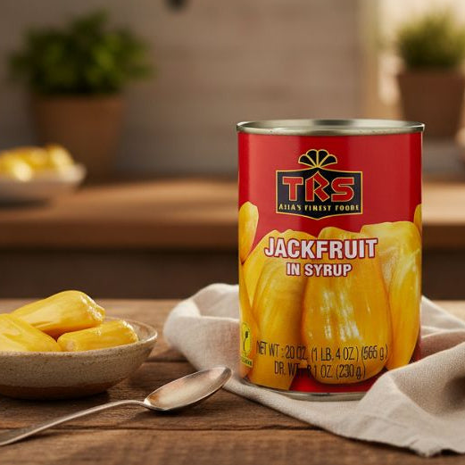 Tin of TRS Jackfruit in Syrup next to a bowl of yellow jackfruit chunks on a wooden table