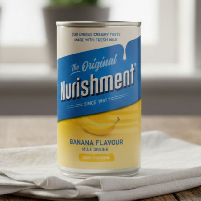 Can of Nurishment Banana Flavour Milk Drink on a wooden surface with a blurred background