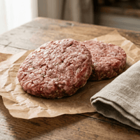 Two raw wild boar and chorizo burger patties on parchment with smoky paprika tones – The Black Farmer