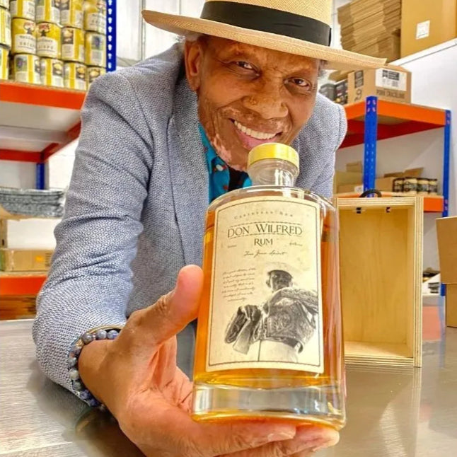 Wilfred_holding_a_bottle_of_Black_Farmer_Rum.webp