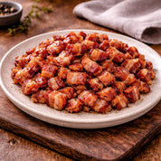 Bacon bits on a white plate with a wooden background