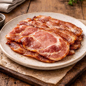 Slices of bacon on a ceramic plate with a wooden background