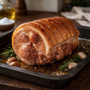 Roasted pork loin with herbs and mushrooms on a baking tray