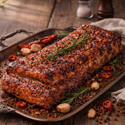 Roasted pork ribs with herbs and spices on a wooden surface