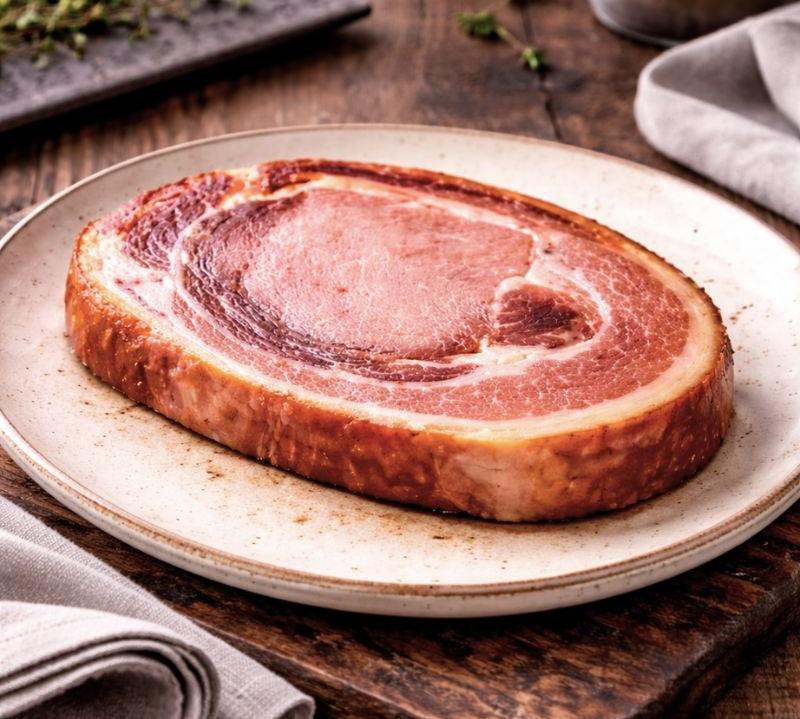 cooked smoked middle bacon on a plate with a wooden background