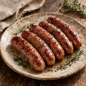 Grilled sausages on a rustic plate with herbs