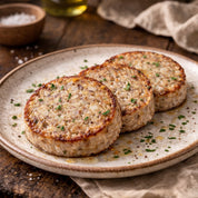 Three white pudding slices on a rustic plate with a wooden background.