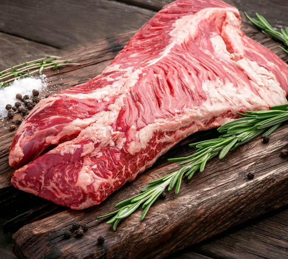 Onglet beef on a wooden cutting board with rosemary and salt