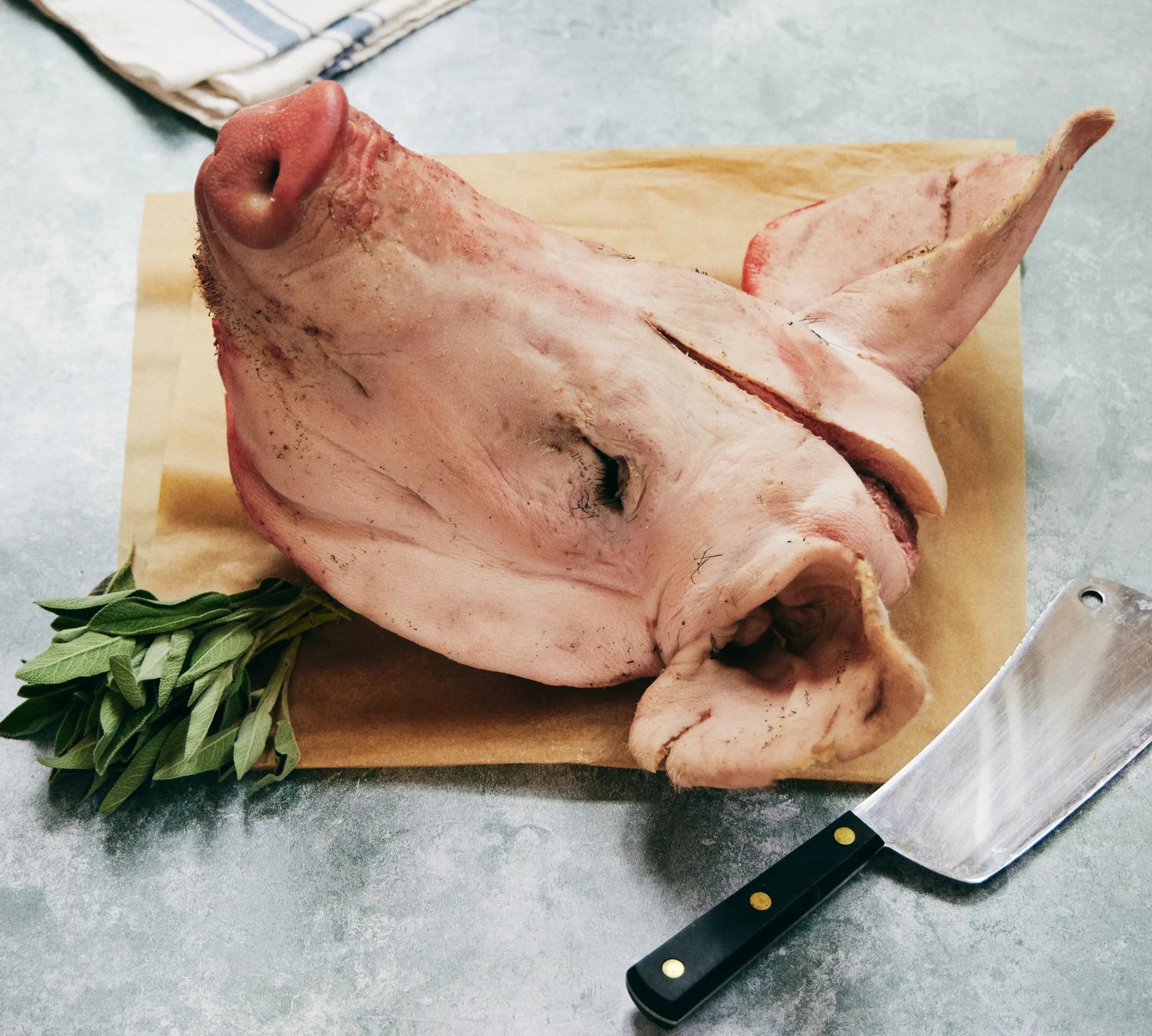 Whole pork head on rustic board – traditional British cut from The Black Farmer, ideal for roasting or braising.