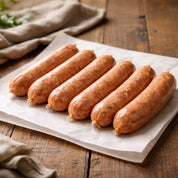 raw chorizo sausages on a wooden cutting board with herbs and spices