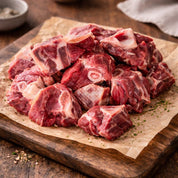 raw goat meat diced bone-in on a wooden board