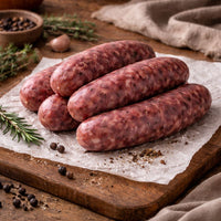 Raw venison sausages on a wooden cutting board with a rustic background