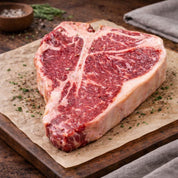 Raw steak on a wooden cutting board with herbs and spices