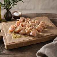 raw chicken breast kebab marinated with garlic and butter glaze on a wooden board

