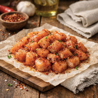 Diced hot-and-spicy chicken breast on parchment with chillies and herbs – The Black Farmer.