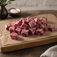 Diced lamb leg pieces displayed fresh and trimmed, premium British lamb ready for cooking.