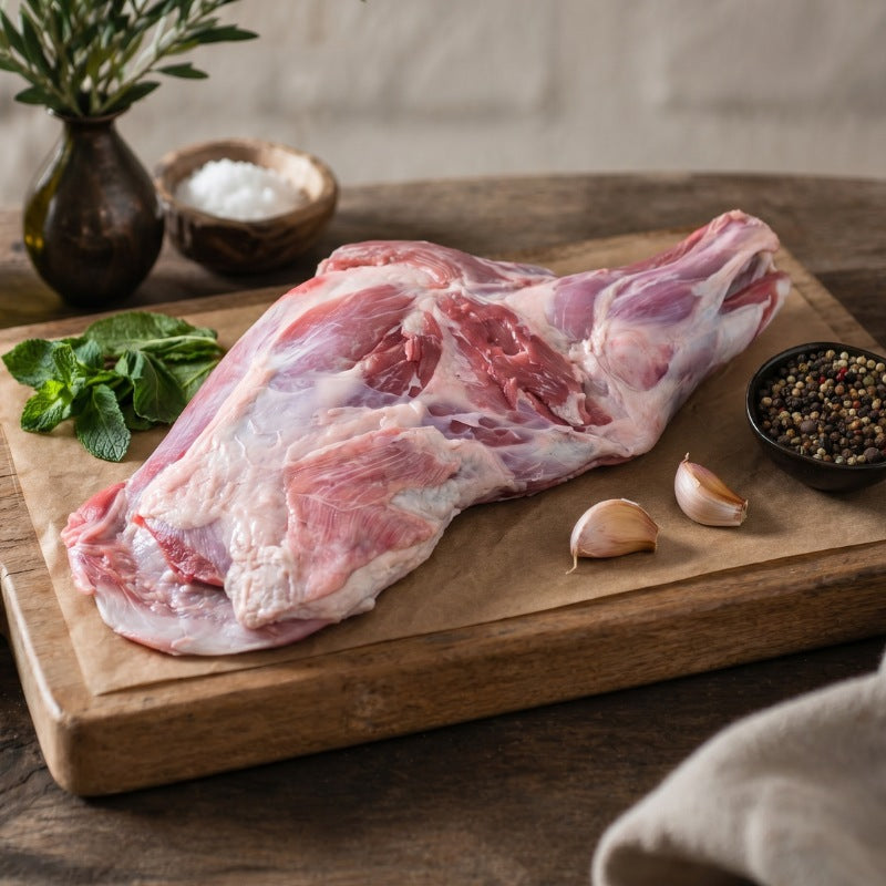 raw lamb shoulder on a wooden rustic board