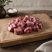 raw diced lamb shoulder on a wooden board
