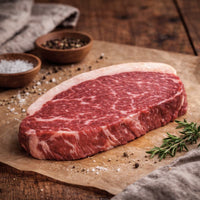 Raw rump steak on a wooden cutting board with spices and herbs